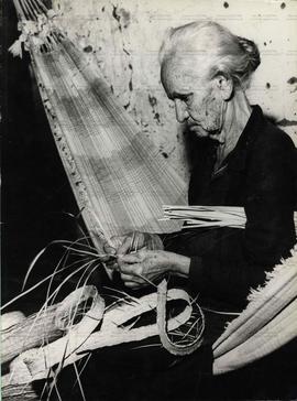 Idosa tece chapéu de palha em época de desemprego na indústria do artesanato (Ceará, abr. 1972). ...