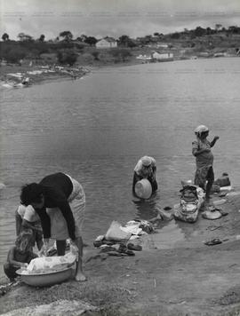 Lavadeiras lavam roupas na beira do rio (Local desconhecido, Data desconhecida). / Crédito: Silve...