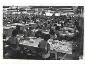 Mulheres trabalham em linha de produção de produtos têxteis (Local desconhecido, Data desconhecida). / Crédito: Silvestre P. Silva.