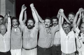 Lula com Hélio Bicudo, João Paulo, entre outros, de punhos erguidos em comício da campanha presid...