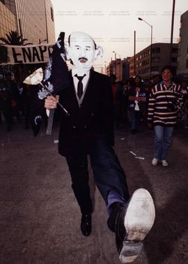 Manifestante com máscara imitando o ex-presidente Carlos Salinas de Gortari (México, fev. 1995). / Crédito: Jorge Nunez/Abril Press.