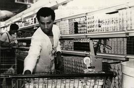 Retrato de trabalhadores marcando preços em alimentos no supermercado (Local desconhecido, Data d...