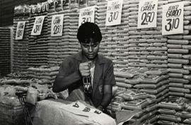 Retrato de trabalhadores marcando preços em alimentos no supermercado (Local desconhecido, Data desconhecida). / Crédito: Roberto Parizotti