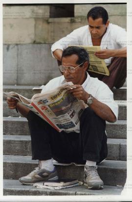 Retrato de homens lendo jornal de empregos (Local desconhecido, 1997). / Crédito: Roberto Parizotti