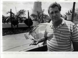 Motorista de taxi em frente a seu carro (Campo  Grande-RJ, 27 set. 1991). / Crédito: Jorge Nunes.